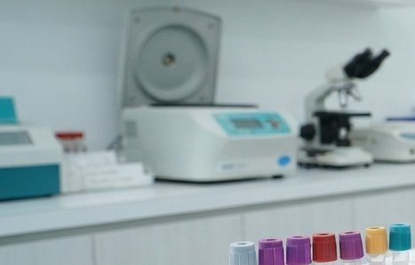 Sudut laboratorium klinik dengan sentrifus, mikroskop, dan rak tabung